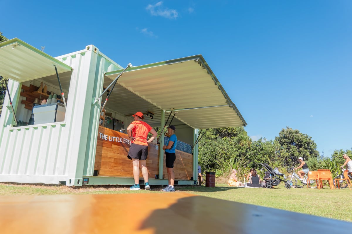 Shipping container converted into a cafe and retail kiosk with timber cladding, serving counter and outdoor seating