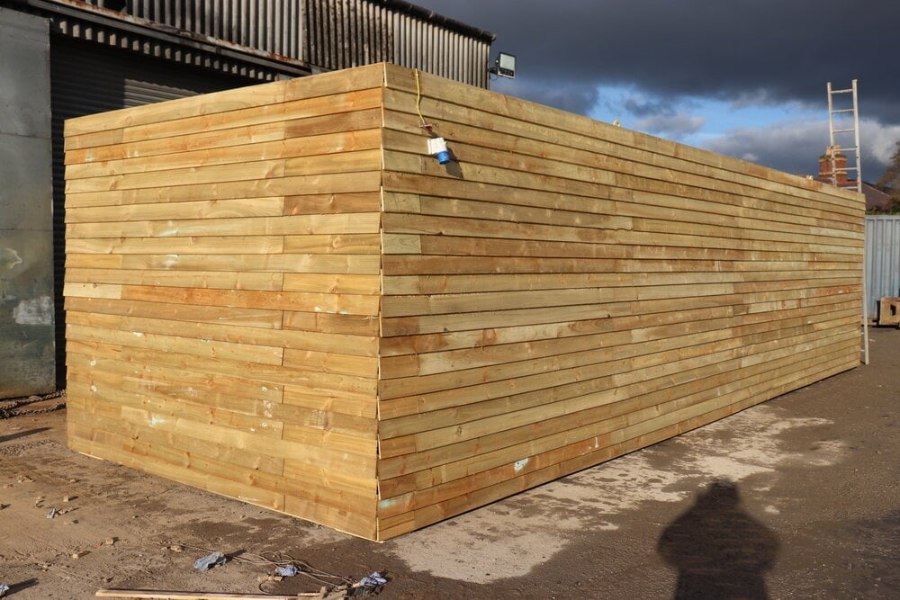 Wooden storage shed with horizontal timber cladding under construction at an industrial site