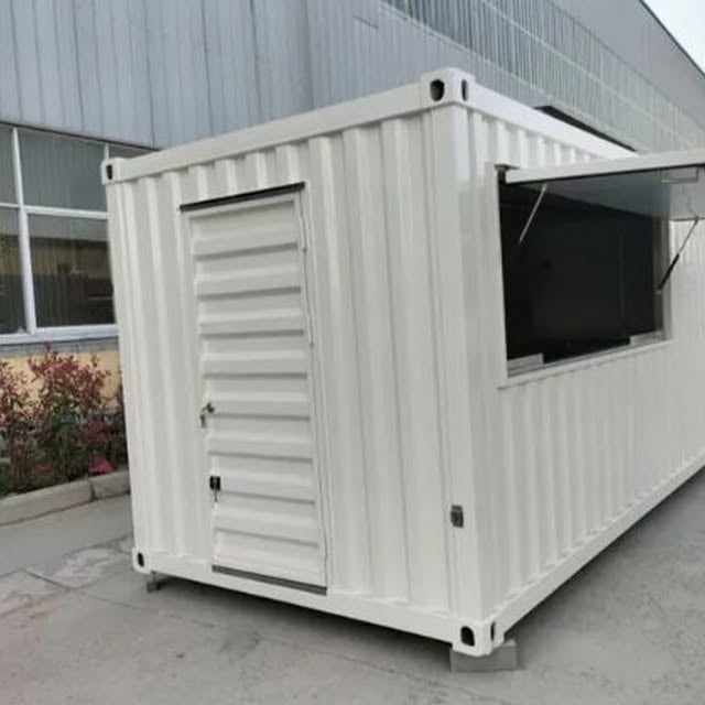 White shipping container converted into a small office or storage unit with louvered door and window
