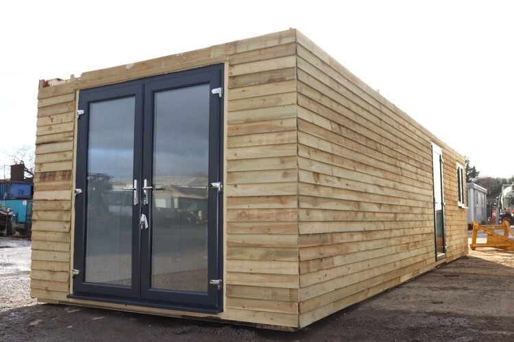 Modern wooden garden office pod with horizontal timber cladding and black glass double doors